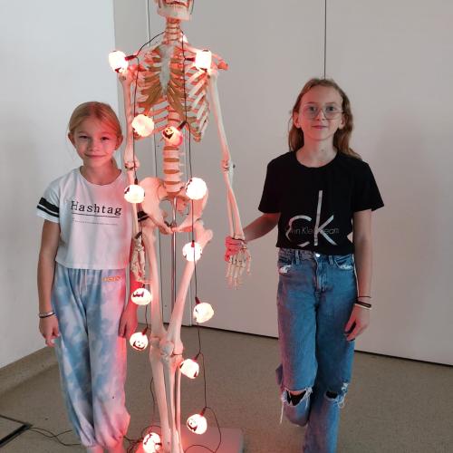 SchülerInnen posieren mit grusligem Skelett