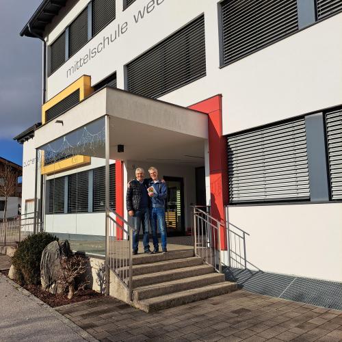 Manfred Gossner mit Direktor Dietmar Auckenthaler vor Schulhaus