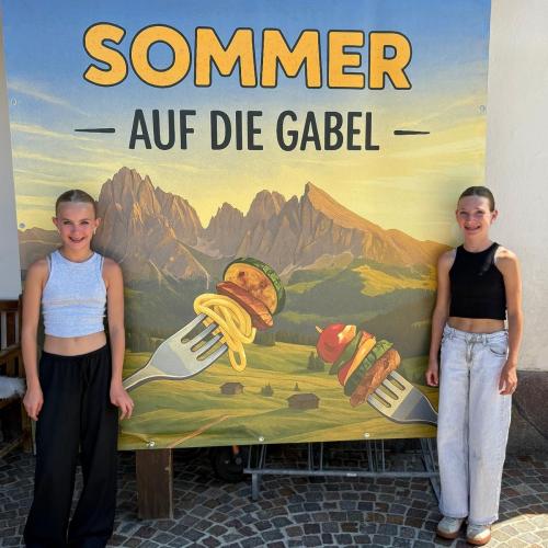 Schülerinnen vor Plakat des Galadiners