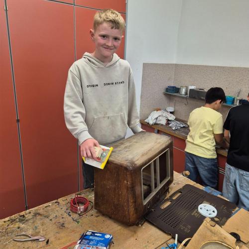 Alexander präpariert das Holz des Radios für den neuen Anstrich